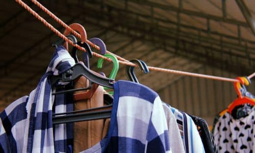 Kleidungsstücke auf Bügeln, die an einer Wäscheleine hängen