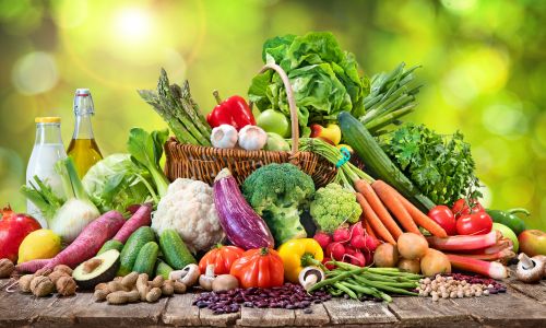 Bunte Auswahl frischer, gesunder Lebensmittel auf einem Holztisch Titel: Ernährungsbewusstsein in der Grundpflege