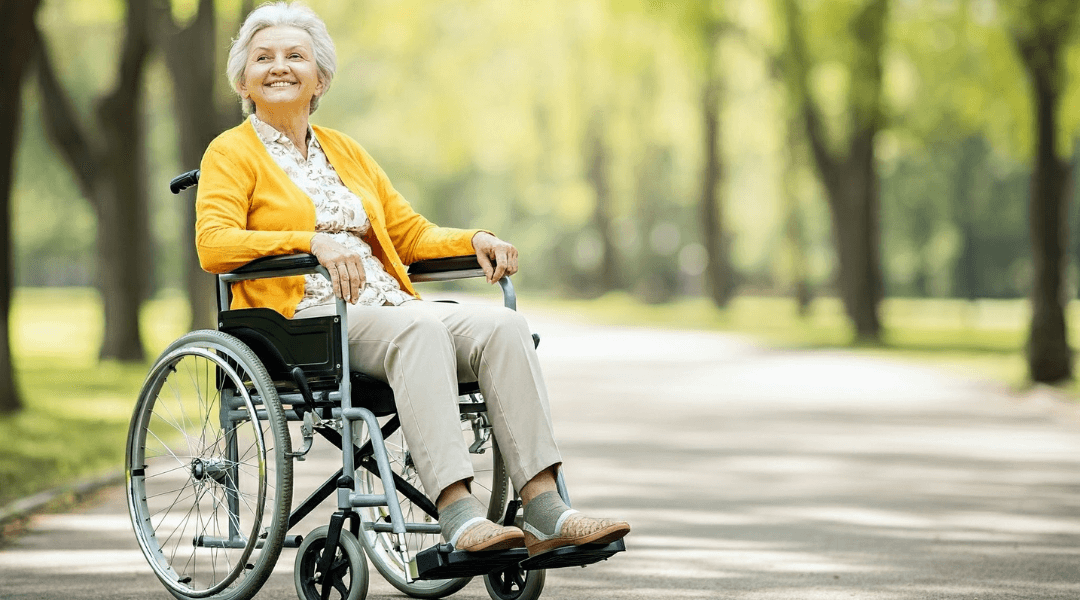Ältere Dame im Rollstuhl genießt einen sonnigen Tag im Park – Beratung zu geeigneten Hilfsmitteln.