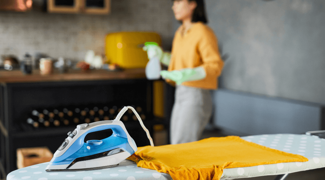 Eine Frau bügelt Kleidung in einer gemütlichen Küche in Berlin.